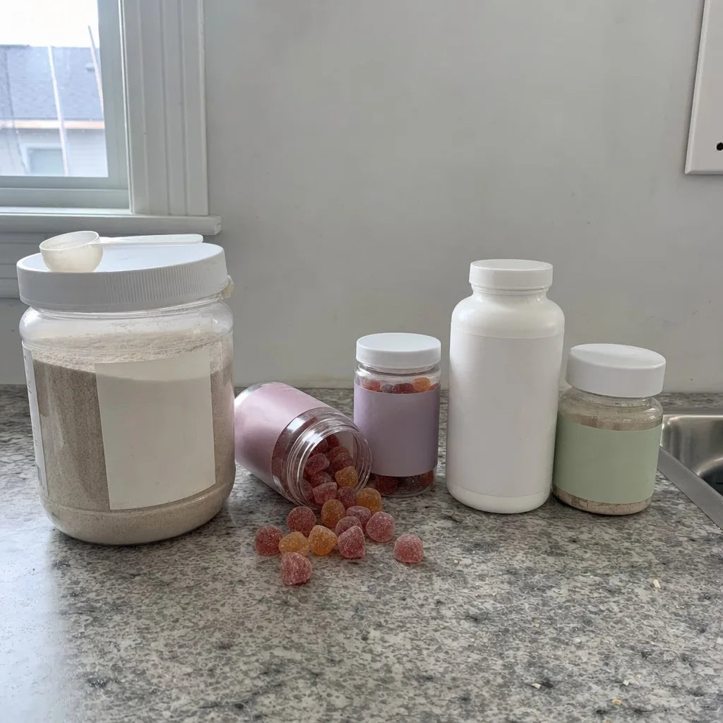 A kitchen counter lined with a fiber powder tub, spilled gummies and probiotic bottles that did not work